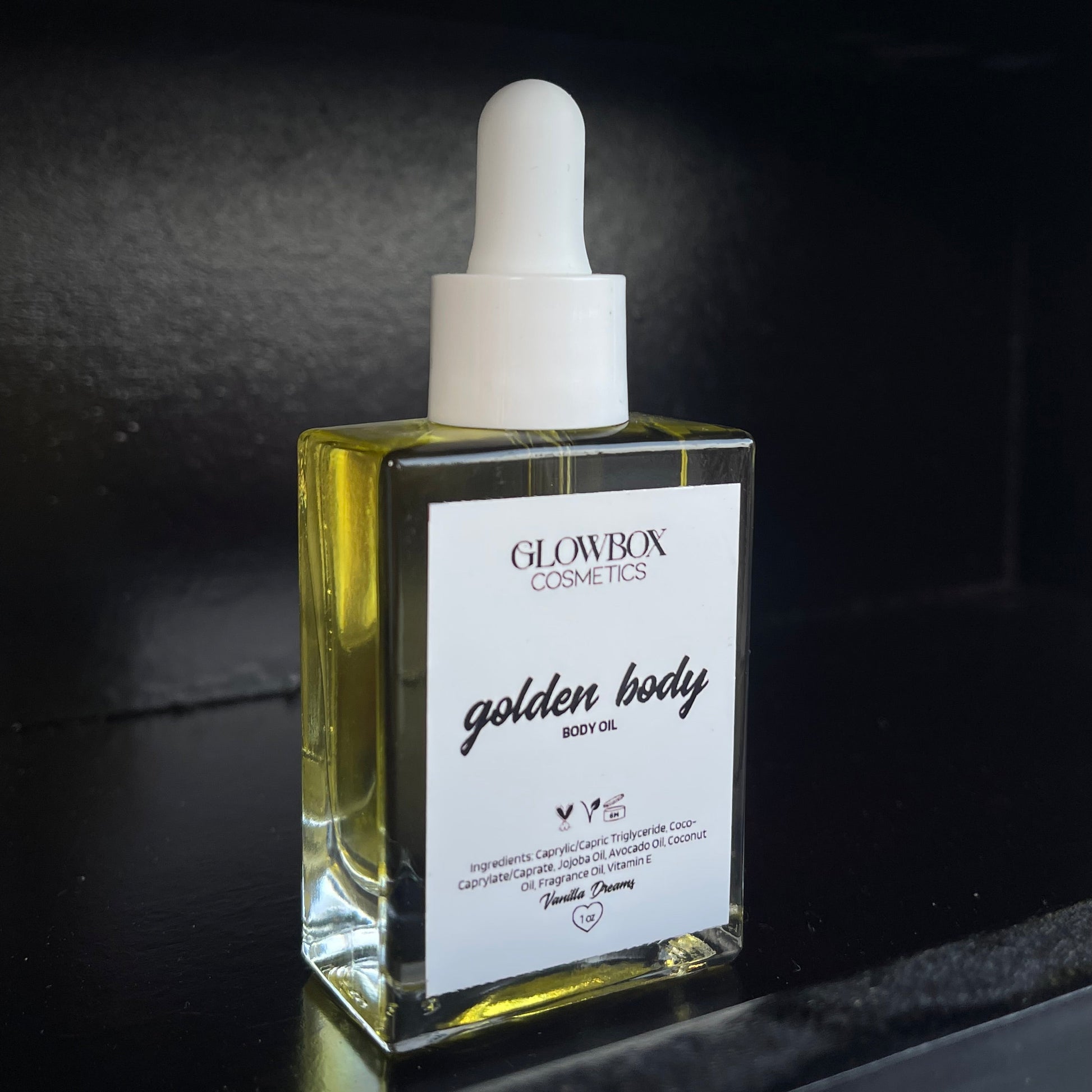 Small bottle with dropper labeled 'golden body' on a dark background