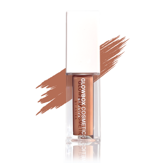 This shiny Amina lip gloss in a clear container with a white cap. The gloss has a nude, caramel brown tint with a thick consistency and is non-sticky. There is a swatch of the gloss shade to the back of the gloss tube. The gloss tube reflection is shown t